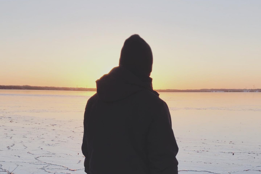 ocean with ice, sunset and a man from behind 